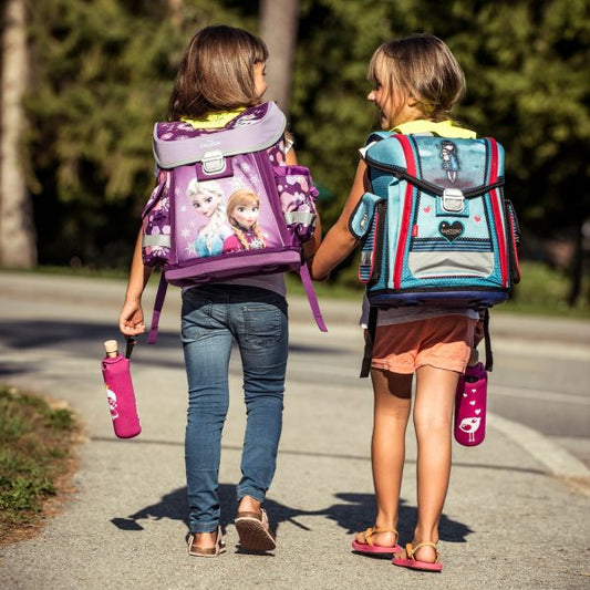 zwei mädchen gehen mit einem rucksack zur schule