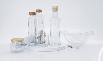 glasflaschen gläser und schale auf einer weisen platte moderne küchenutensilien