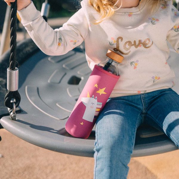 junges mädchen auf einer schaukel mit einhorn wasserflasche